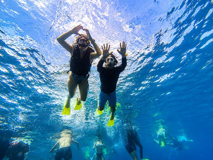 Friends making a heart shape underwater while snorkeling in Nusa Penida